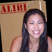 Smiling woman with long dark hair in front of a manila folder stamped "Alibi"